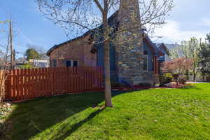 View of side of property featuring stone siding and a chimney