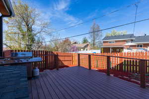 Wooden terrace with a fenced backyard and a residential view