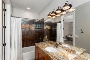 Bathroom featuring vanity, shower / bath combo, a textured ceiling, and recessed lighting