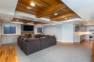Living area featuring light wood-style floors, recessed lighting, a fireplace, and a wood ceiling with exposed beams