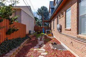 View of side of home featuring brick siding and a central AC unit