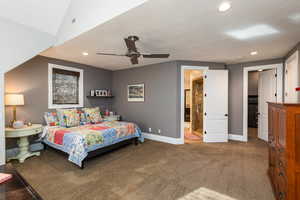 Bedroom with connected bathroom, dark carpet, a ceiling fan, a textured ceiling, and recessed lighting