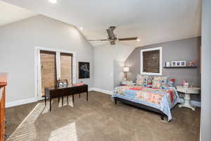 Carpeted bedroom featuring lofted ceiling, a ceiling fan, and recessed lighting