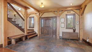 Foyer with stairs and stone tile floors