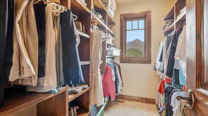 Walk in closet featuring light carpet