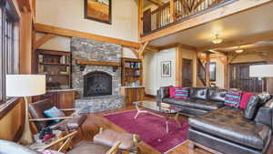 Living area with a fireplace, hardwood / wood-style flooring, and built in shelves