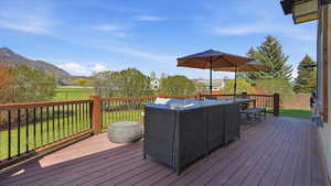 Deck featuring outdoor dining area, a yard, and a mountain view