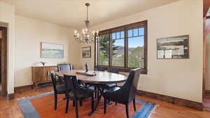 Dining room with light wood-type flooring, suspended lighting, and a mountain view