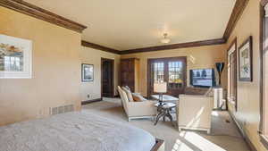 Bedroom with light carpet and crown molding
