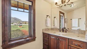 Half bath featuring vanity, a mountain view, and suspended lighting