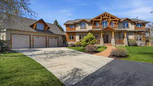 Craftsman inspired home featuring a front lawn, covered porch, driveway, stone siding, and stucco siding