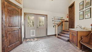 Entrance foyer featuring brick flooring and lofted ceiling
