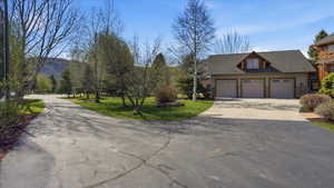 View of front of property with concrete driveway, an attached garage, and a front yard