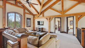 Living area featuring carpet flooring, vaulted ceiling, and ceiling fan