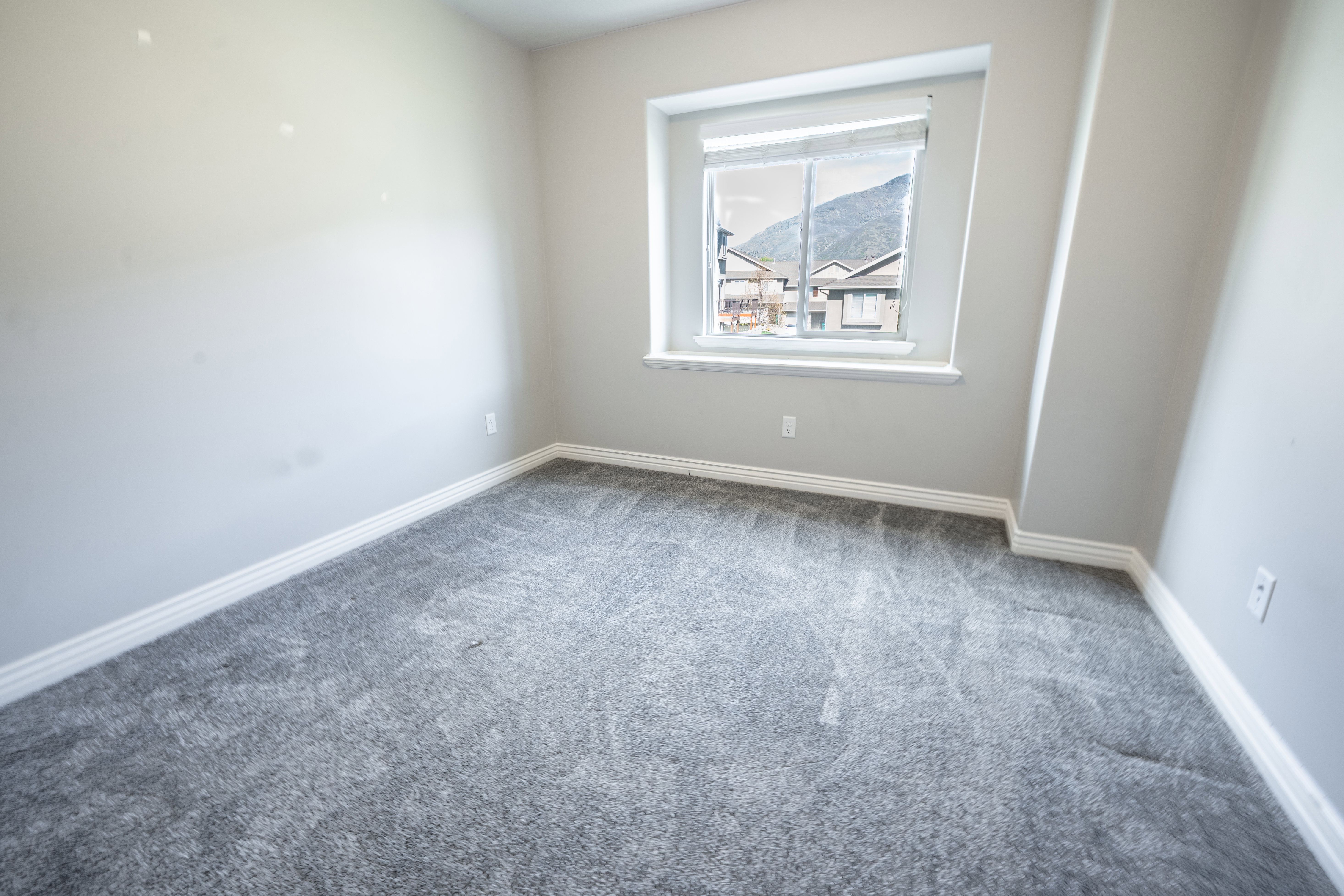 Carpeted empty room with baseboards