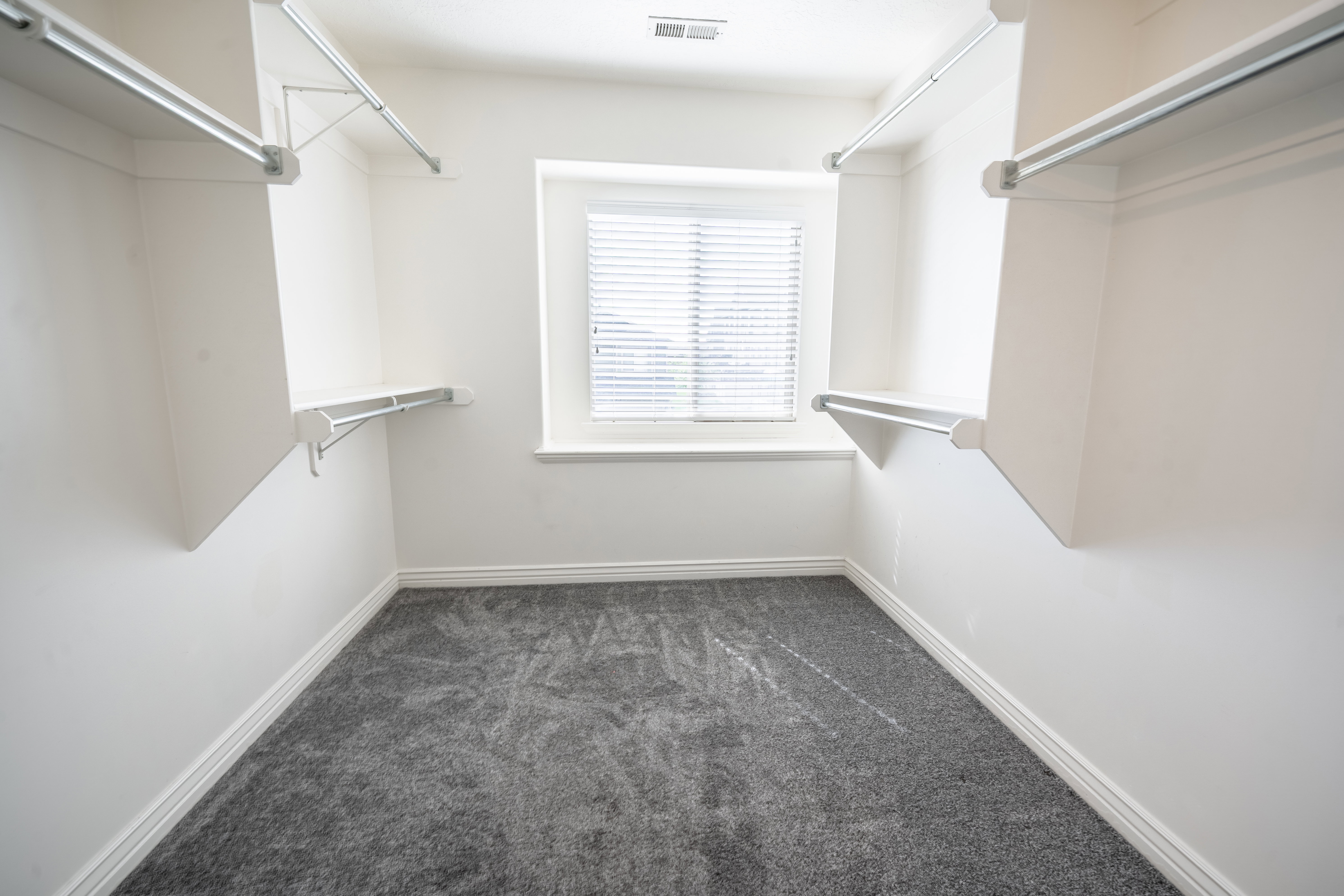 Walk in closet featuring dark colored carpet