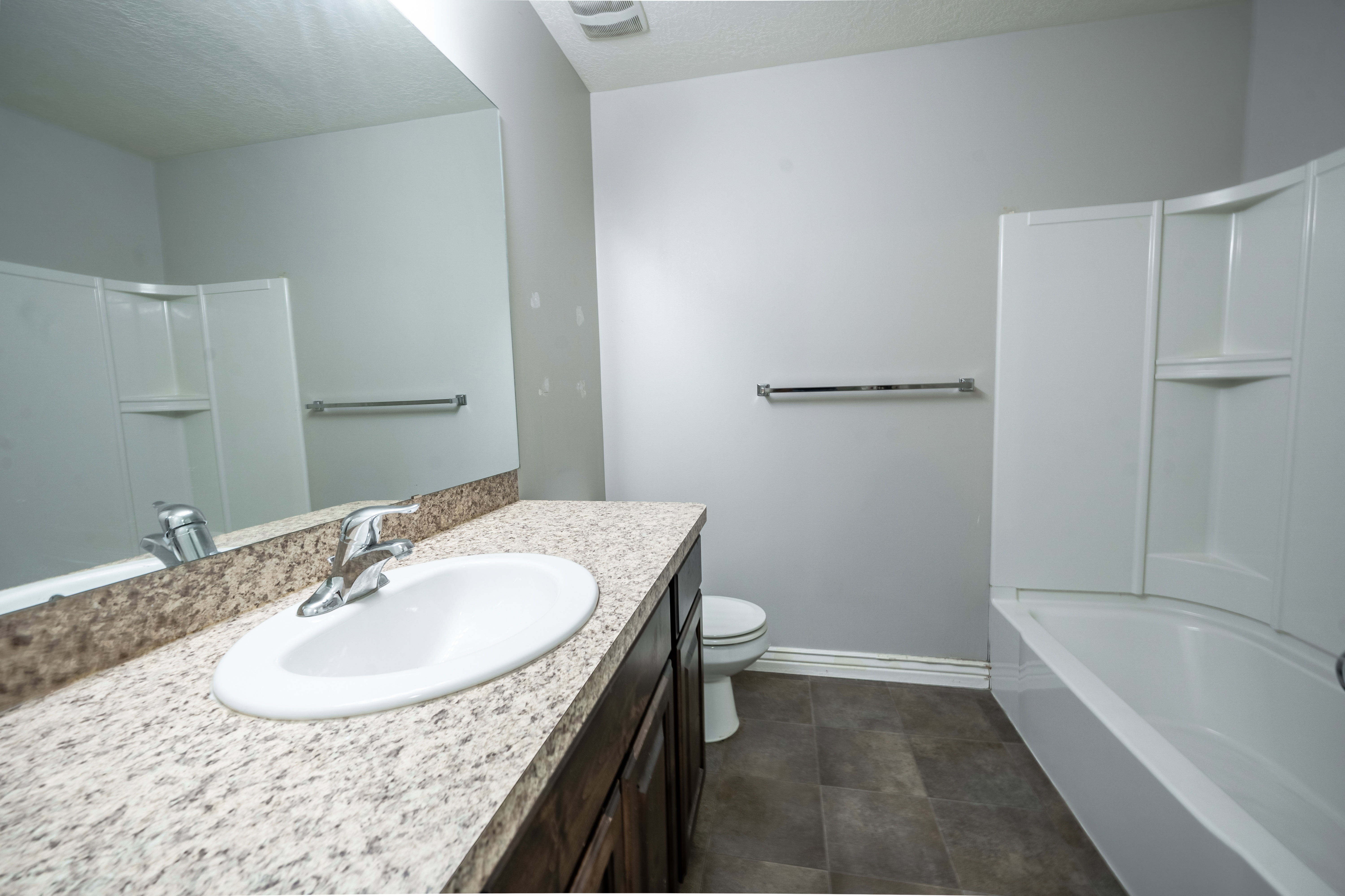 Full bathroom featuring vanity, shower / bath combination, and a textured ceiling