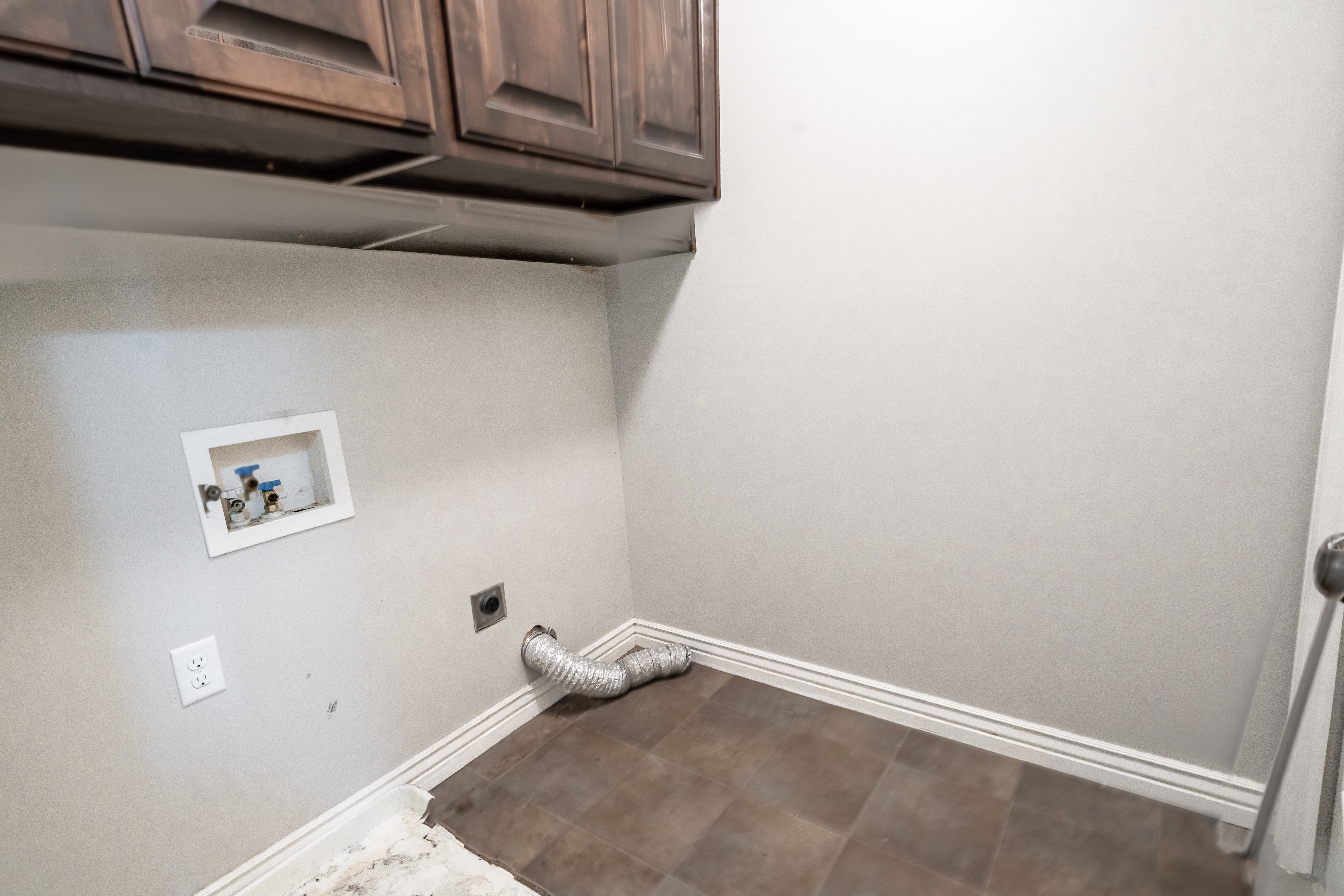 Laundry area with electric dryer hookup, cabinet space, and washer hookup