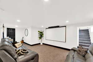 Home theater room with light carpet and recessed lighting