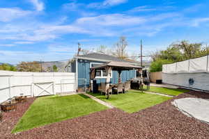 Back of property with a gazebo, a patio, a gate, an outdoor lounge area, and a fenced backyard