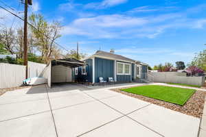 Rear view of property with board and batten siding, a patio, a detached carport, and concrete driveway