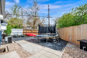 Fenced backyard with a patio area and a trampoline