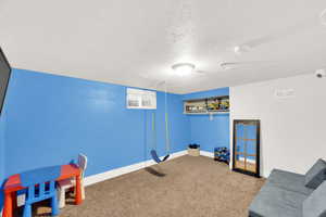 Playroom with a textured ceiling and carpet