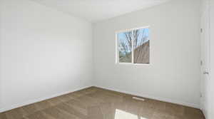 Carpeted empty room featuring baseboards