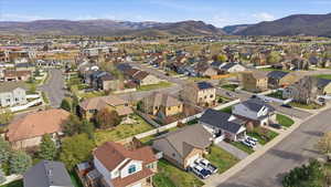 Aerial overview of property's location with a mountainous background and nearby suburban area