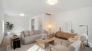 Carpeted living area featuring baseboards