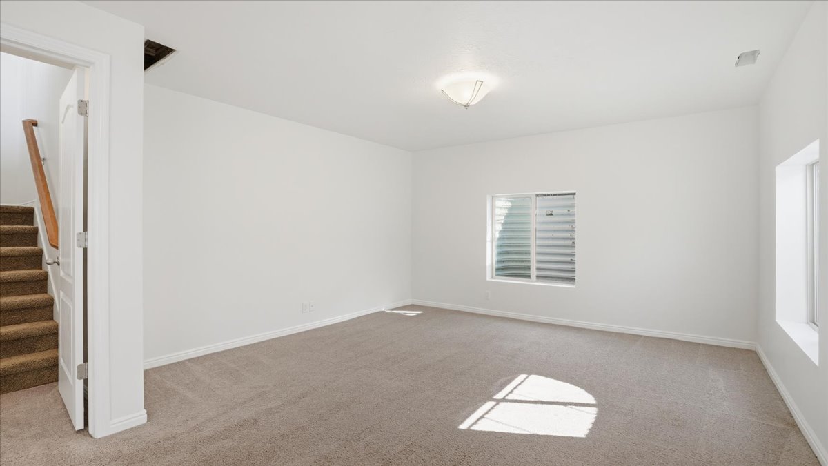 Empty room featuring light carpet