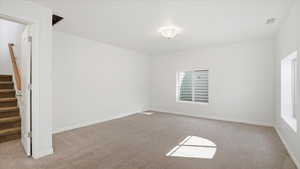 Empty room featuring light carpet