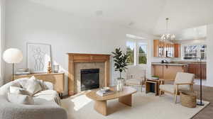 Living room featuring hanging lights, lofted ceiling, a fireplace, and light carpet