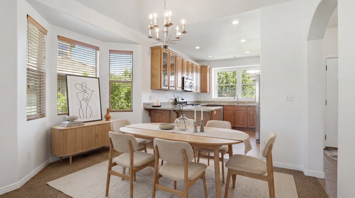Dining area with an elegant chandelier, wood-finish flooring, and a bay window featuring horizontal blinds