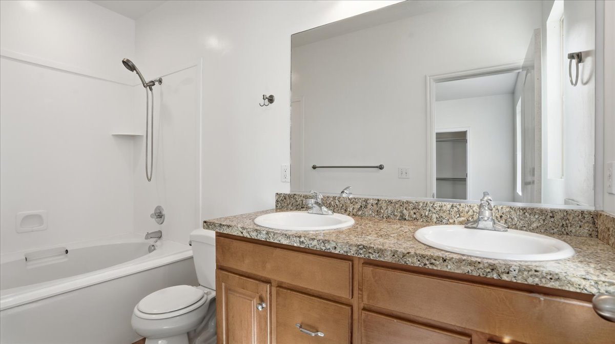 Bathroom with double vanity and tub / shower combination