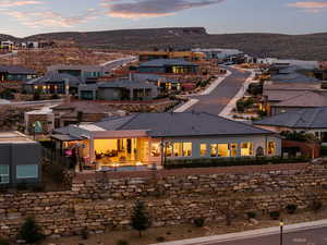 Back of house at dusk with a fenced backyard, a patio area, a mountain view, and a residential view
