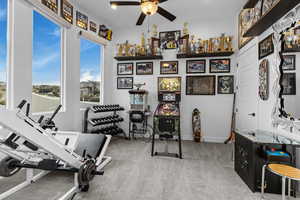 Workout area featuring ceiling fan and light colored carpet