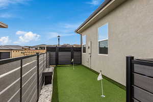 View of yard featuring a balcony, a putting green, and a residential view