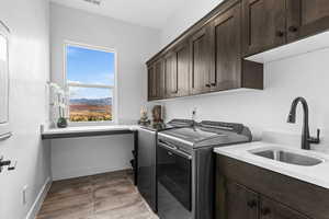 Laundry room with cabinet space, washing machine and clothes dryer, and light tile patterned floors