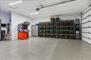 Garage featuring strapped water heater and baseboards