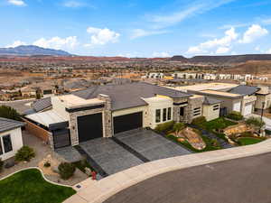 View of front of house with a garage, a residential view, a mountain view, and driveway