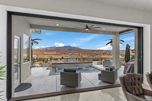 View of patio with ceiling fan, a mountain view, an outdoor lounge area, and grilling area