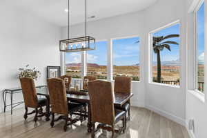 Dining area with light wood-type flooring, a mountain view, and hanging lights