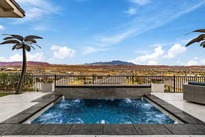 View of pool featuring patio surround, a swimming pool, a mountain view, and a jacuzzi