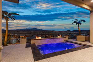Pool at dusk featuring a patio area, an outdoor pool, an outdoor fire pit, and a mountain view