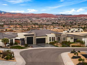 View of front of house featuring stone siding, a garage, a mountain view, and a residential view