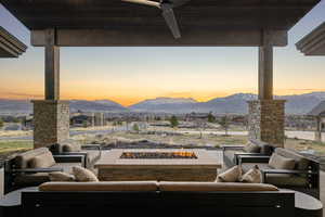 View of patio with an outdoor living space with a fire pit, a ceiling fan, and a mountain view
