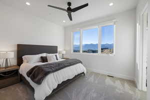 Bedroom with a mountain view, light carpet, ceiling fan, and recessed lighting