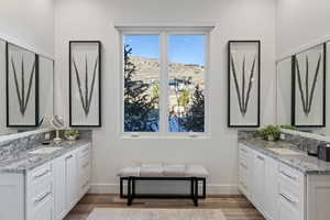 Bathroom featuring two vanities and light wood finished floors