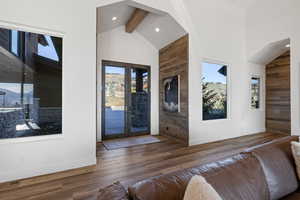 Entryway with wood finished floors, french doors, healthy amount of natural light, lofted ceiling, and recessed lighting